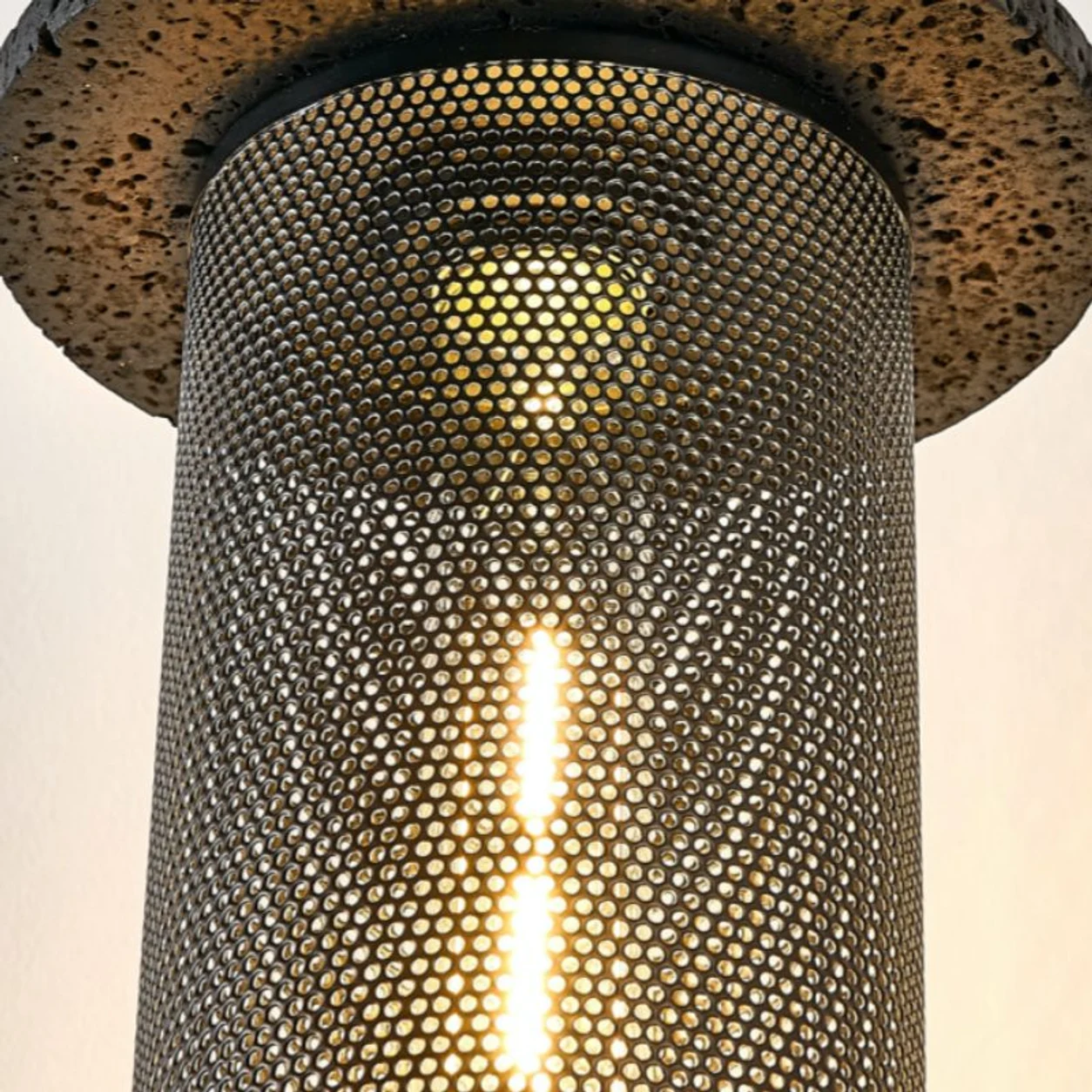 Close detail of the lit perforated woven pendant shade
