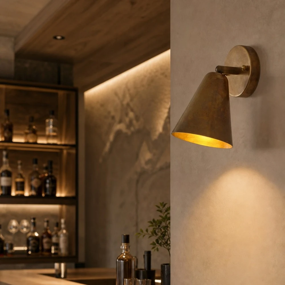 Brass cone wall lamp in a warm lounge setting
