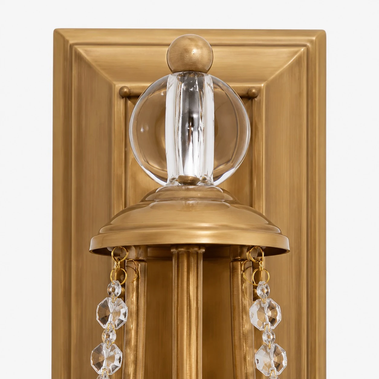 Close view of carved brass backplate and crystal ornament