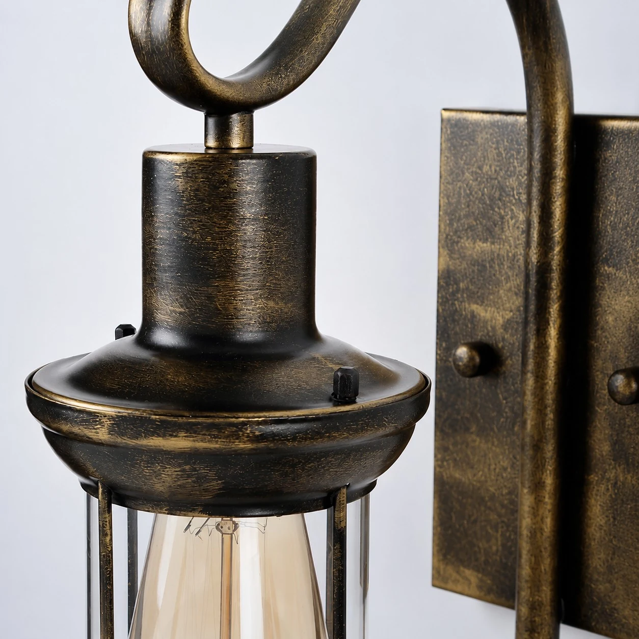 Close view of antique bronze metal cap and clear glass shade