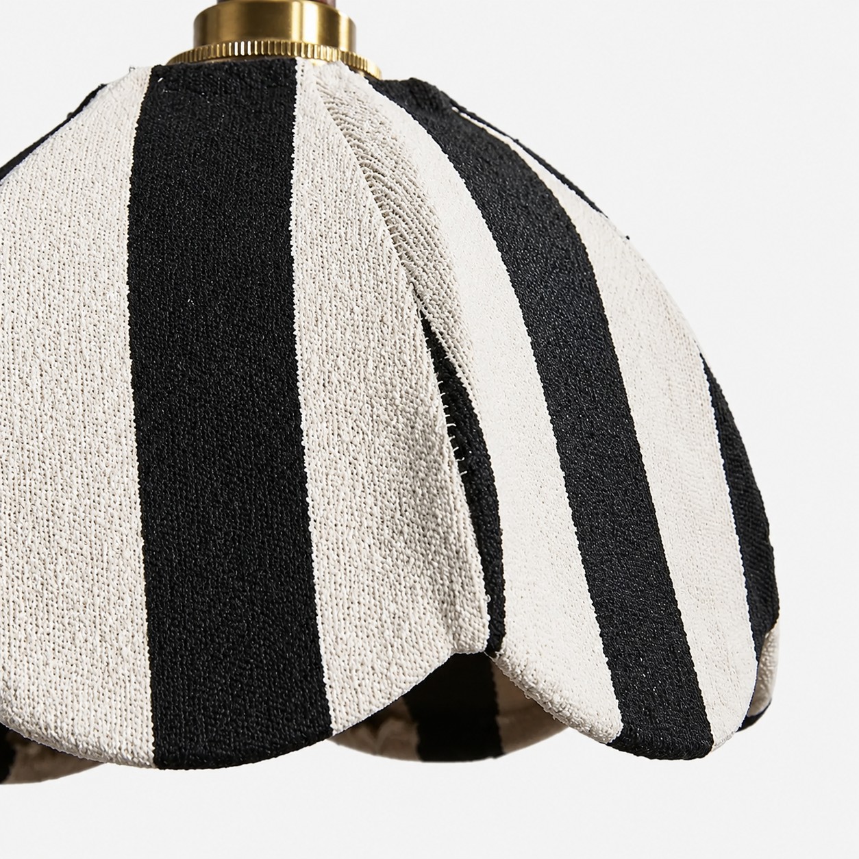 Close-up of black and ivory striped textured fabric shade with scalloped petal shape