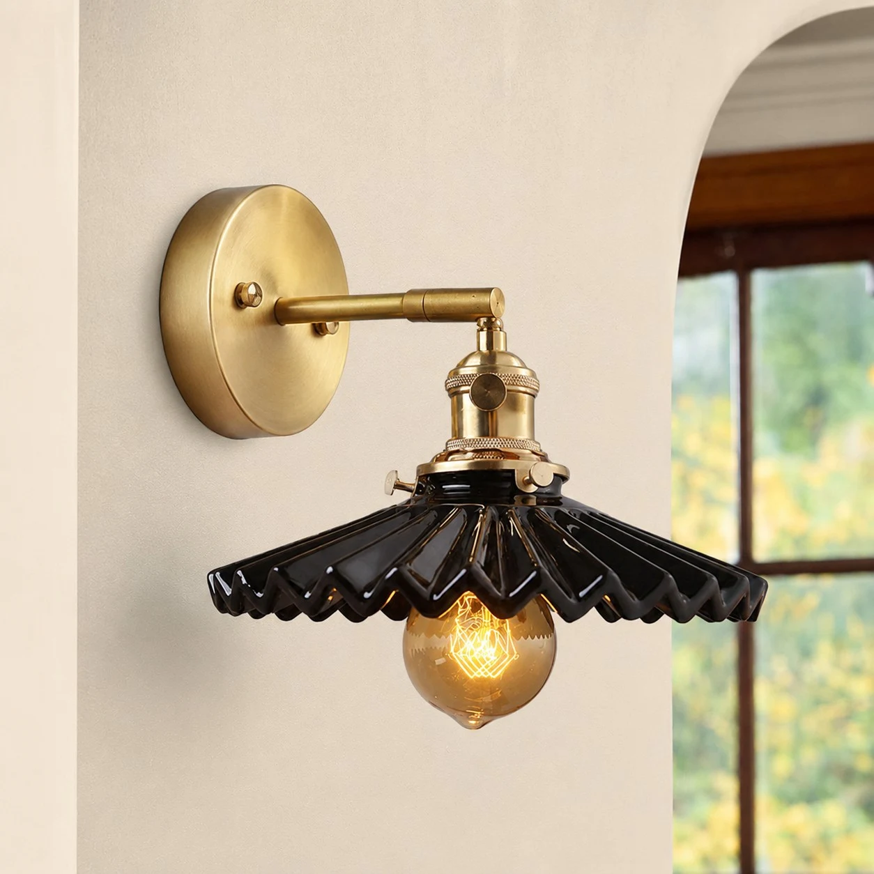 Black ceramic wall sconce near arched window