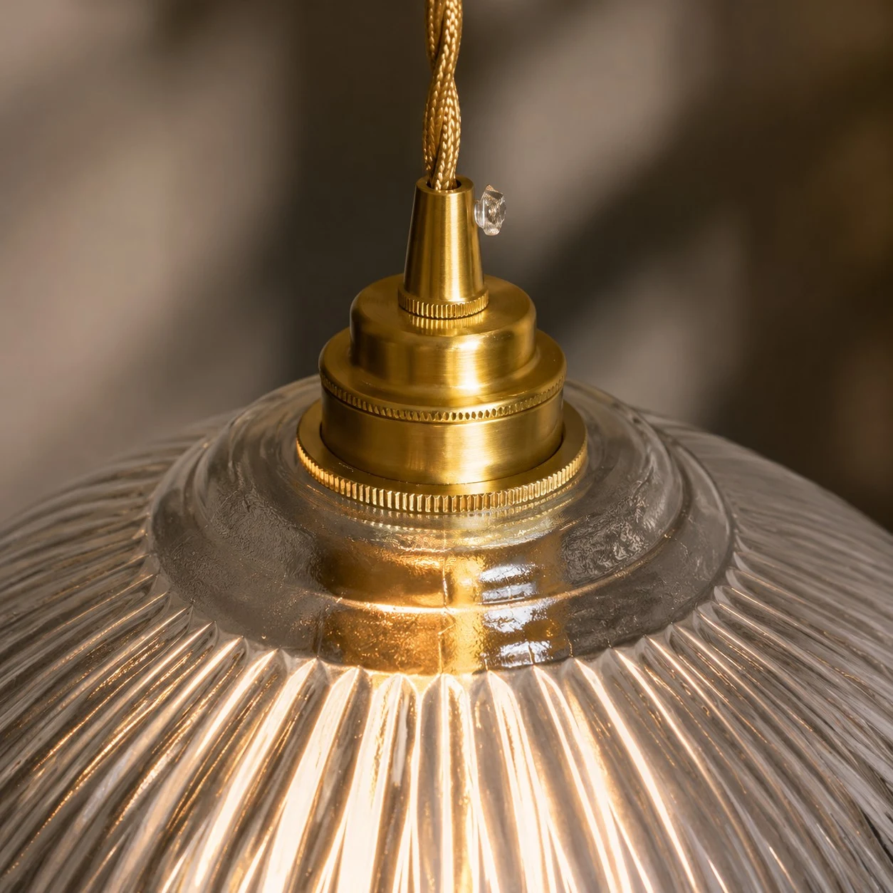 Brass cap and ribbed glass detail of the pendant light
