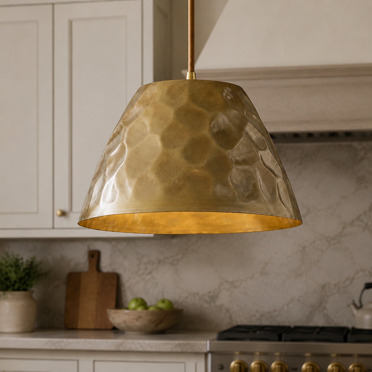 Hammered brass pendant light above a kitchen island