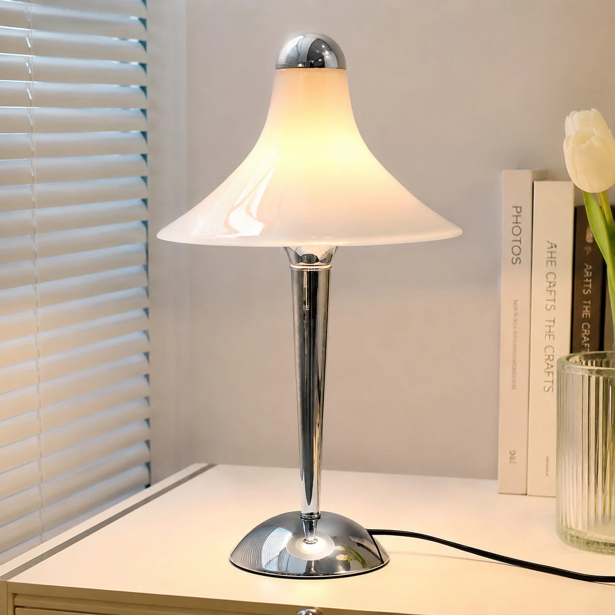 White table lamp on a sideboard with books