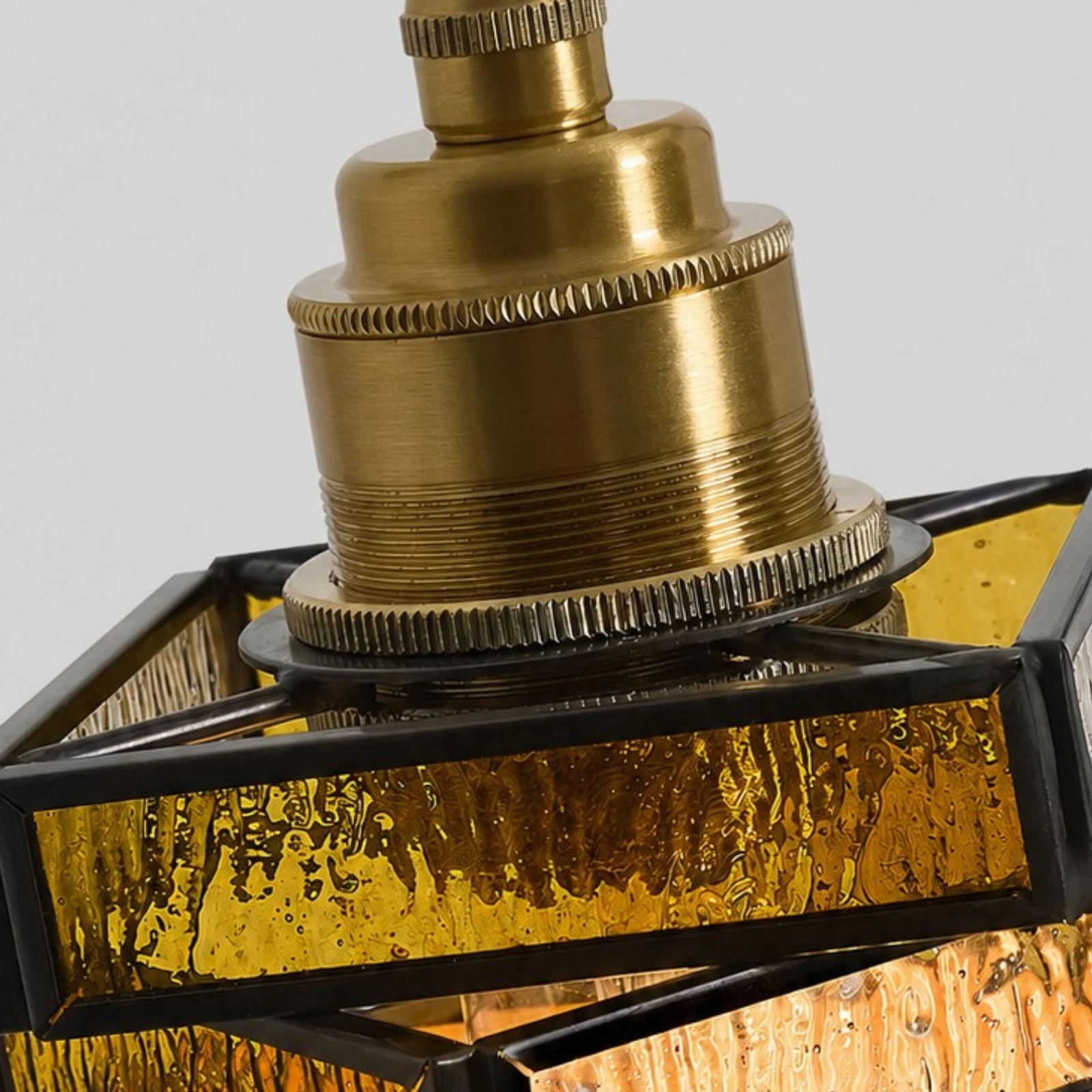 Brass-tone socket and stained glass frame detail