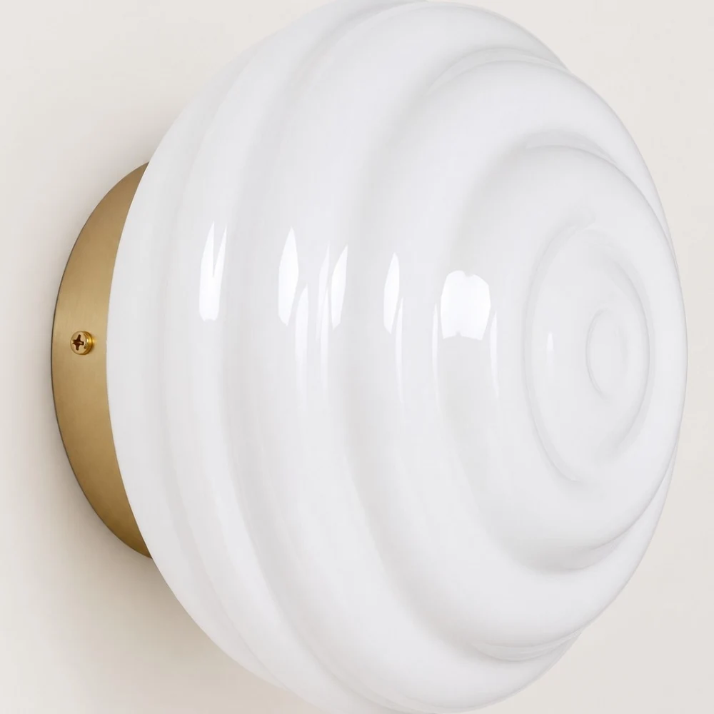 Glossy white ribbed glass shade and round metal wall plate detail