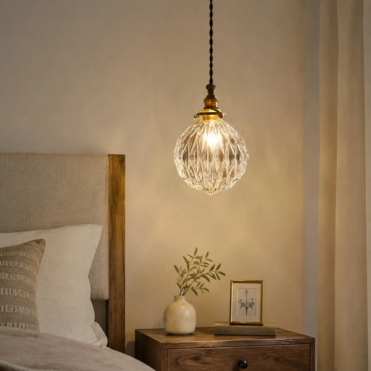 ribbed clear glass pendant light glowing over a bedside nightstand