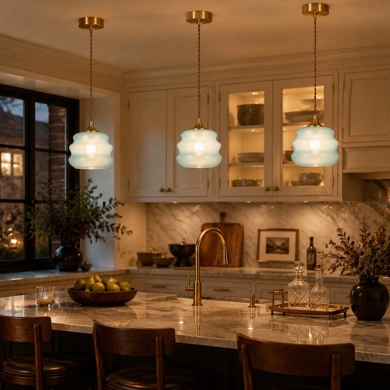 Three pendant lights glowing above a kitchen island