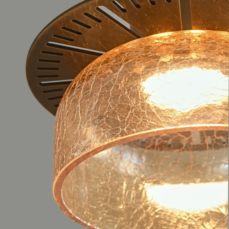 Amber glass pendant shade glowing beneath a brass top