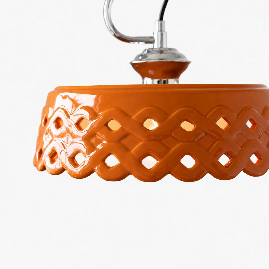 Glossy orange metal and ceramic shade with pierced wave pattern