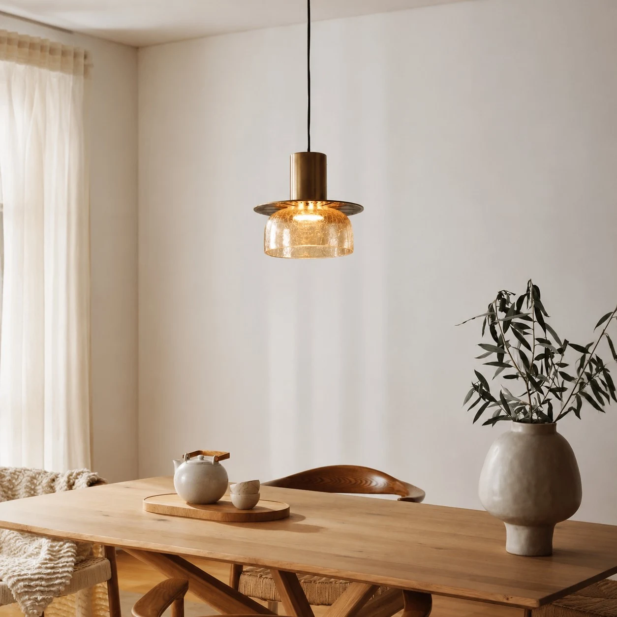 Amber brass glass pendant light above a wood dining table