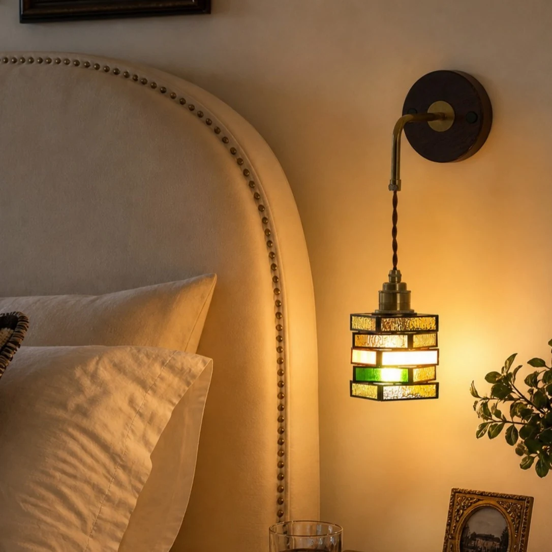 Colorful glass wall sconce beside a bed