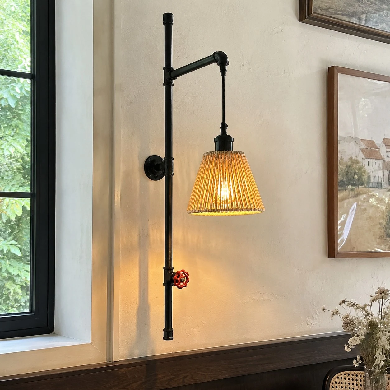 Pipe wall sconce beside framed wall decor