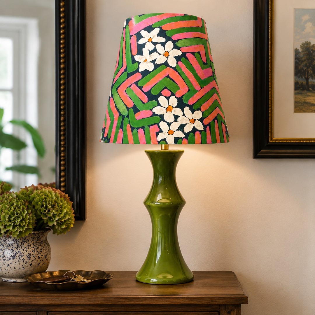 Pink and green table lamp on a wooden console