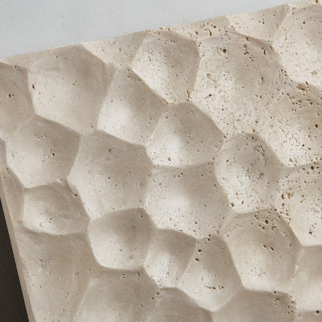 Carved stone relief face detail on a square travertine wall lamp